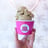 a person holding a cupcake in a pink cup