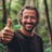 a man with a beard and a beard smiles while holding a banana peel