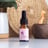 A dropper bottle of Souaad's prickly pear seed oil set in front of other skincare tools and wicker basket