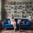 a woman in a room with a blue couch and lots of pictures on the wall