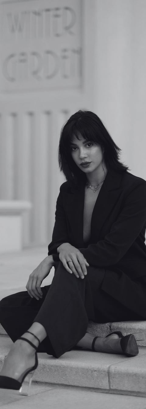 a well dressed woman with high standards wearing heels sitting outside a building