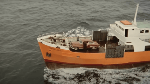 A large orange boat in the water.