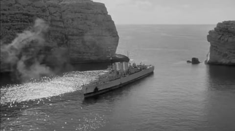 A World War II battle ship moored in a bay.