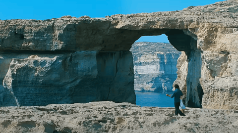 A couple dance in front of the Azure Window.