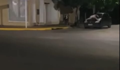 a car driving down a street with a car in the background