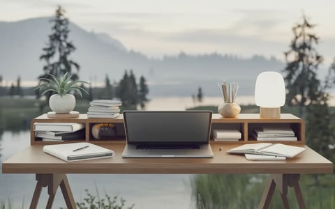 a laptop computer sitting on a desk with a laptop and a lamp