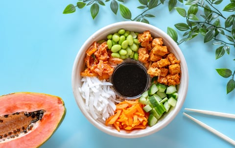 a bowl of food with chopsticks and exotic fruit