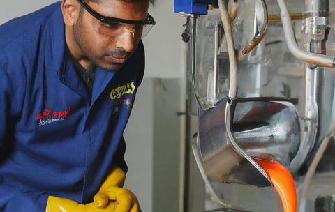a man in a blue shirt and yellow gloves