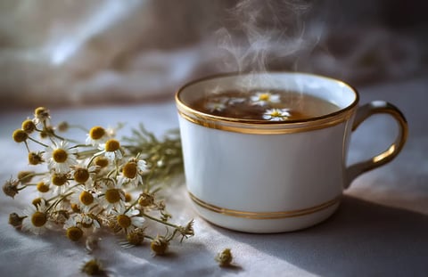 ultra realistic and extremely photographic image of a cup of steaming chamomile tea, with dried flow