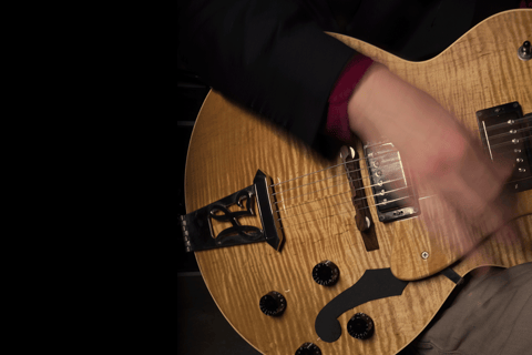 a hand rapidly strumming a guitar