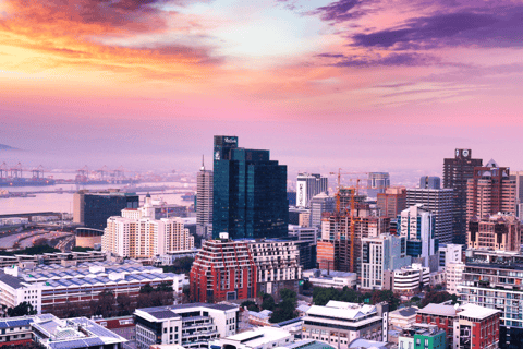 a city skyline with a colorful sunset and a view of the city