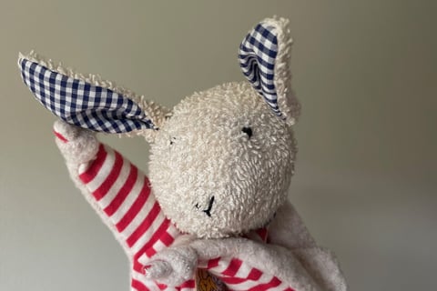 a stuffed animal rabbit dressed in a red and white striped dress