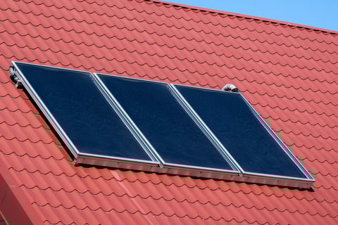 a house with a red roof and a solar paneled roof