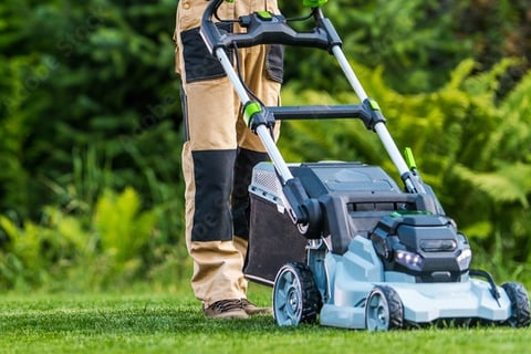 a man in a hat and gloves is using a lawn mower