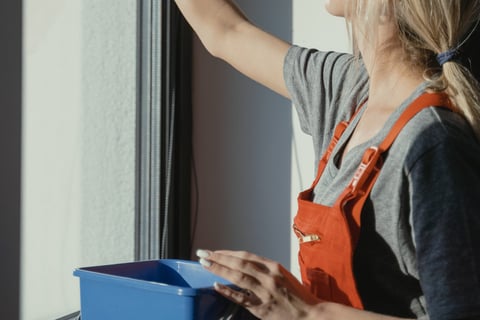 a woman cleaning a window with a rag rag rag rag rag rag rag rag rag