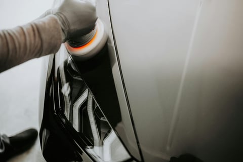 a person polishing a car's hood- buffing a car hood at fix collision center