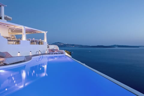 a pool with a view of the ocean from Katikies Hotel Santorini