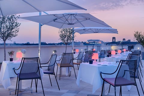 a restaurant with tables and umbrellas on a roof top