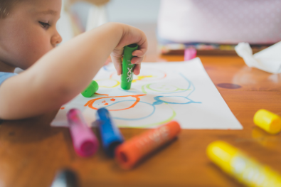 preschooler drawing with markers on paper