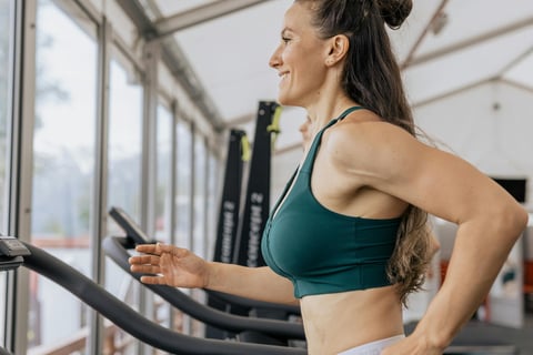 a woman in a green sports bra top and white shorts