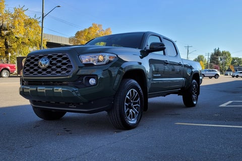 a green toyota tacoma sei truck parked in a parking lot