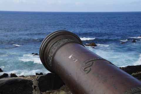 a cannon wheel cannon on a rocky beach