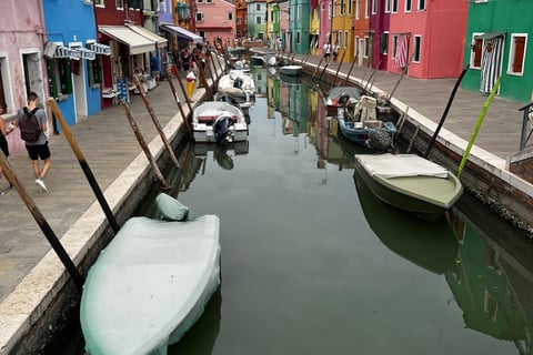 pequenos barcos ancorados em canal e casinhas coloridas em volta