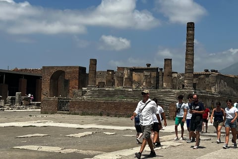 grupo de turistas andando pelos restos da cidade de Pompeia