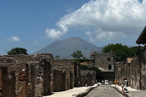 visitantes em uma ruela de Pompeia com o monte Vesúvio ao fundo