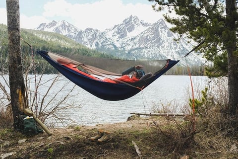 a man in a hammock with a backpack on a hammock