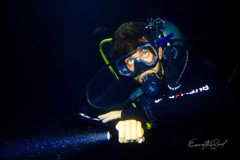 Male scuba diver with torch at ight in Gili Trawangan