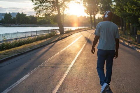 a man skateboarding down a street in the sun