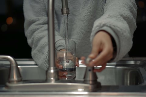 Woman turns on the kitchen sink