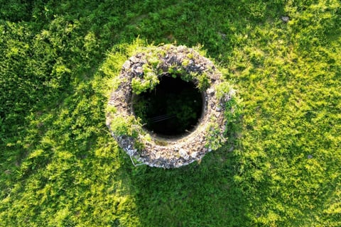 well opening in a grassy field