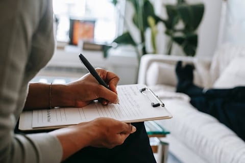 a person holding a pen and writing on a notebook