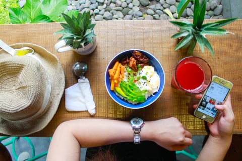 a person sitting at a table with a bowl of food. A quick boost for her mental health due to this.