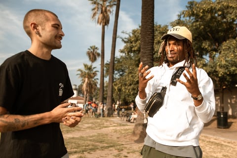 two men talking to each other at a park fostering a social connection for their mental health