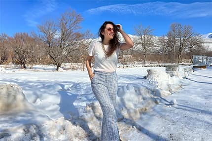 a woman in a white shirt and plaid pants