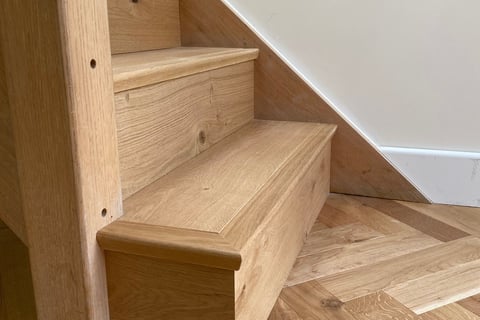 An oak herringbone floor with matching plank on the staircase
