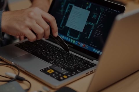 a person is using a laptop computer and a pen