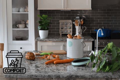 Kitchen compost bin on a countertop with vegetable peels, eggshells, and food scraps, composting