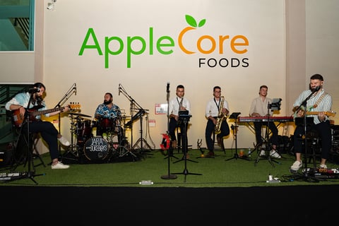 a band of musicians performing at an applecore foods event