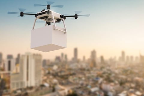 Drone flying over a congested city to demonstrate the concept of clean, emissions-free delivery.