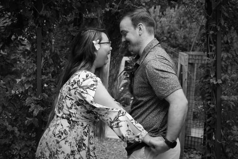 Engagement day photo of Sarah and Donny laughing and holding hands while looking at each other.