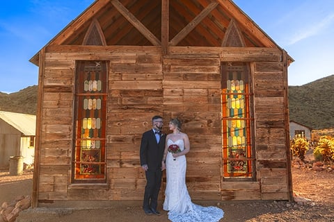 a bride and groom standing in front of a church