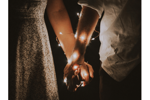 holding hands with fairy lights wrapped around, healthy relationship
