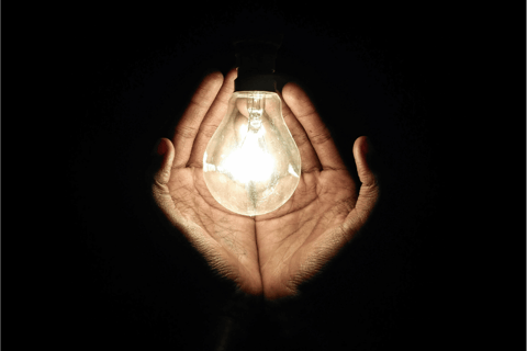 Hands holding a lightbulb, a symbol of healthy boundaries