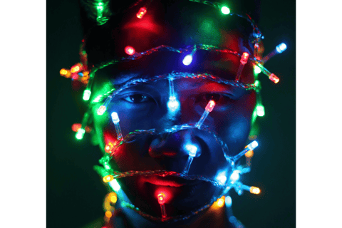 A man's head wrapped in fairy lights, a symbol of their needs and expectations in relationships