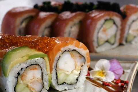 a plate of sushi rolls with a sauced and sauce