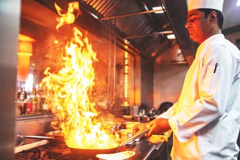 Culinary arts student preparing gourmet dish in professional kitchen